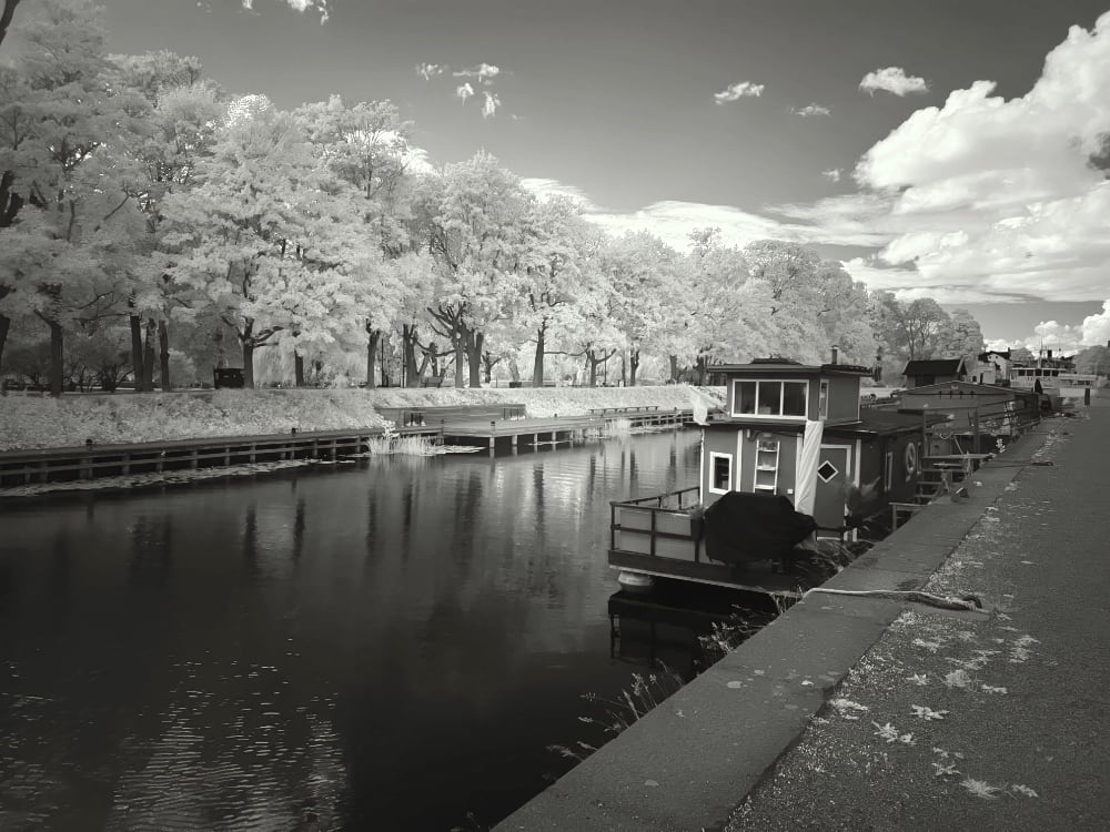 Black and white Infrared image of a boat in a river canal