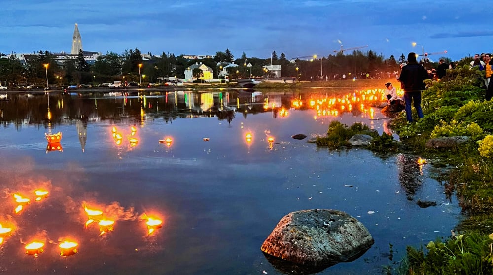 Burning candles floating on the surface of the water.