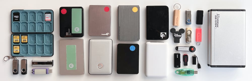 A collection of portable hard drives, USB sticks and SD cards.