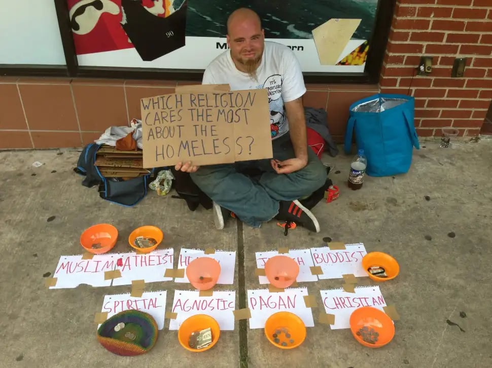 Photo of a homeless man with 9 bowls accepting tips. Each bowl is labelled with a different world religion.