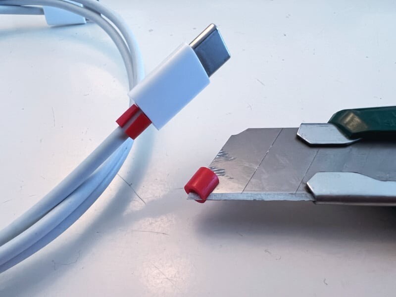 The knife slices the plastic bead long-ways and another is wrapped it around the cable.