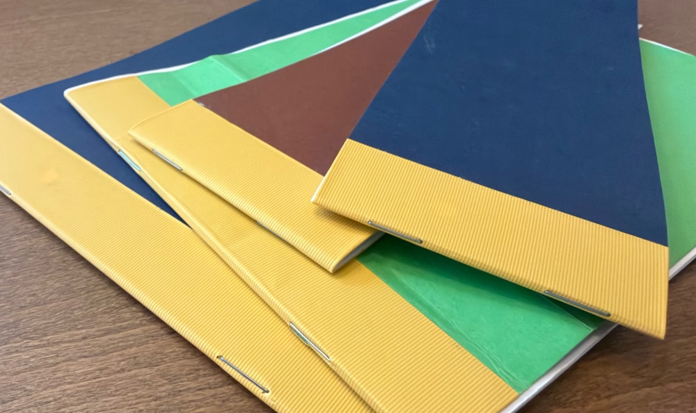 A pile of homemade half and quarter notebooks